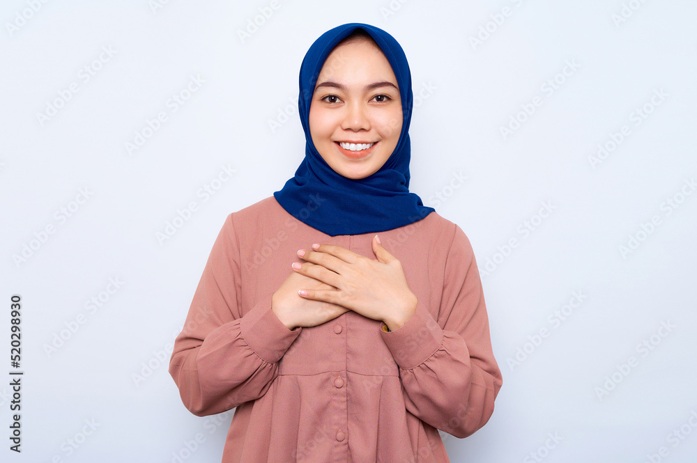 Portrait of charming young Asian muslim woman put hands on chest respect proud isolated over white background. People religious lifestyle concept Portrait of charming young Asian muslim woman put hands on chest respect proud isolated over white background. People religious lifestyle concept