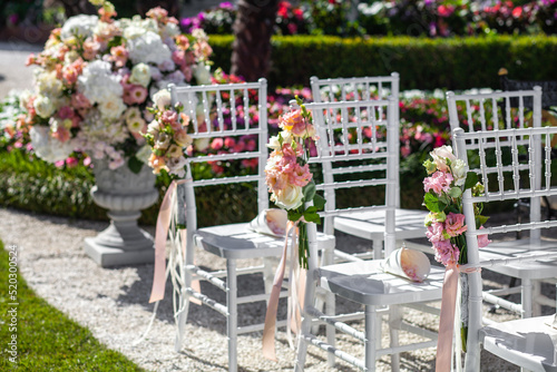 Wooden chairs with flowers at the wedding ceremony