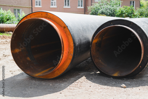 Plumbing repair outdoors concept. Two new industrial pipes lying on ground, close-up