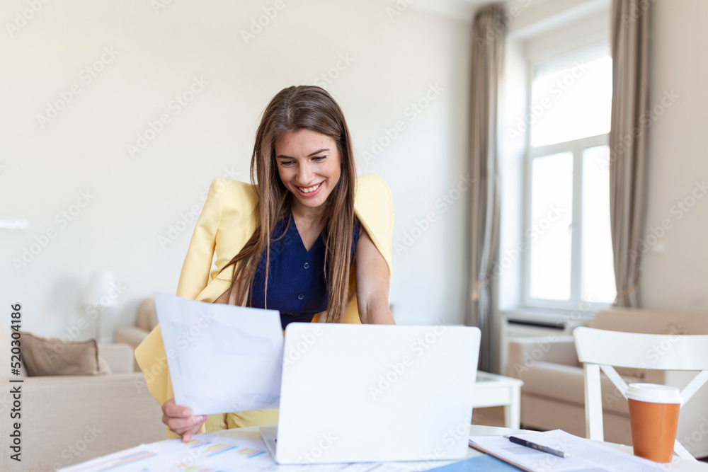 Entrepreneurship. Business Woman Checking Documents Using Laptop Working Standing In Home Office. Free Space, Selective Focus Entrepreneurship. Business Woman Checking Documents Using Laptop Working Standing In Home Office. Free Space, Selective Focus