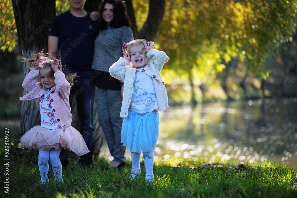 Fototapeta premium Leaf fall in the park. Children for a walk in the autumn park. Family. Fall. Happiness.