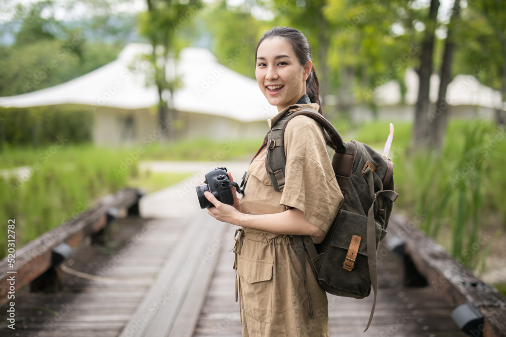 Fototapeta premium Asian girl backpack in nature the mountains of Khao Yai , Relax time on holiday concept travel,Photographer Travel Sightseeing Wander Hobby Recreation Concept 
