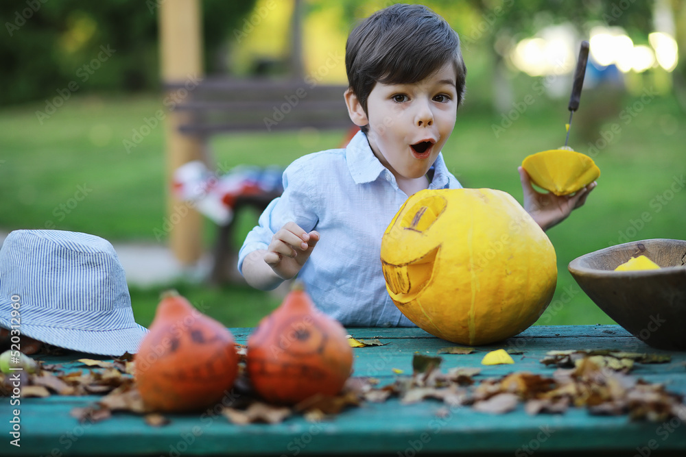 Fototapeta premium Autumn traditions and preparations for the holiday Halloween. A house in nature, a lamp made of pumpkins is cutting out at the table.