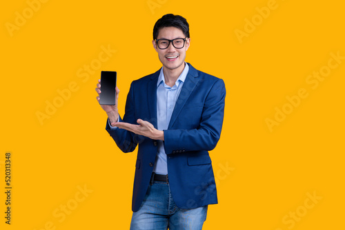 smart casual asian businessman wear glasses hand hold coffee sup showing blank screen monitor smartphone,smiling asia man hand present smartphone black screen studio shot yellow background