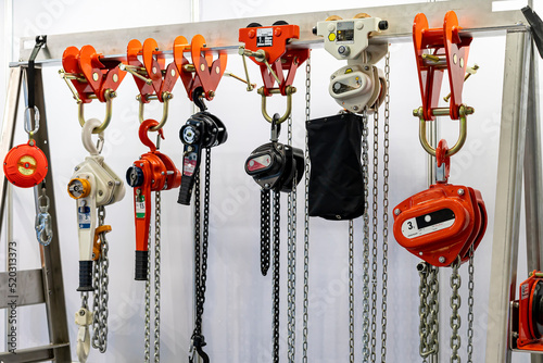 Close up various kind of industrial manual chain hoist such as hand pull and lever type for lifting object and reduce work load storage on hanger line photo