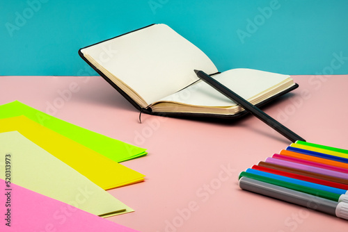 Back to school  with school supplies on top of a pink table with a blue background.