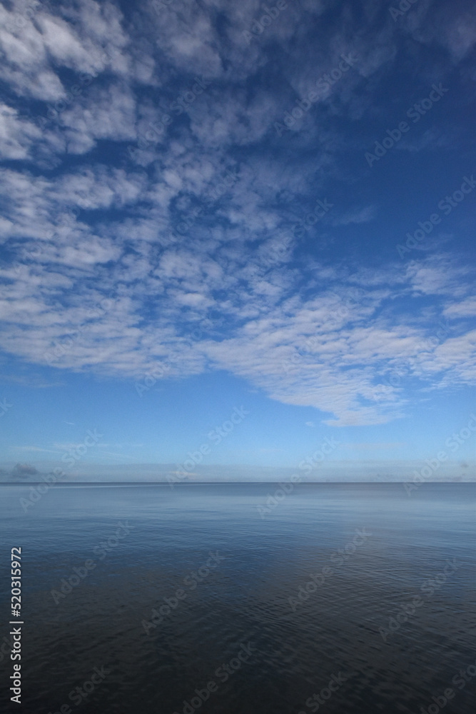 風がない波の穏やかな湾内の海と澄み切った青空、夏の朝の風景