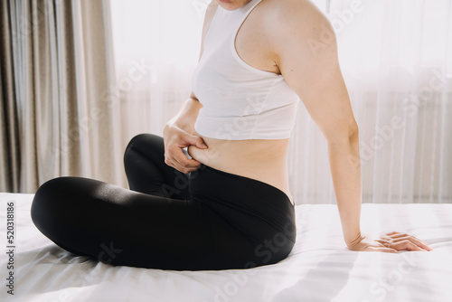 Obraz na plátne Beautiful fat woman with tape measure She uses her hand to squeeze the excess fat that is isolated on a white background