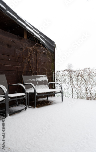 Garden furniture under the snow. Winter precipitation and a thick layer of snow on the garden furniture.