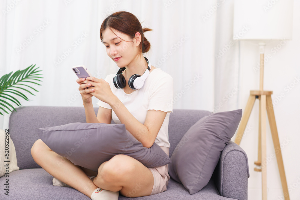 Lifestyle in living room concept, Young Asian woman using smartphone to surfing social media Lifestyle in living room concept, Young Asian woman using smartphone to surfing social media