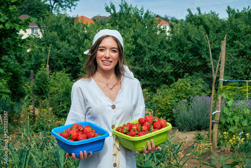 Obraz na płótnie Young woman holding a harvest of strawberries in her hands w salonie