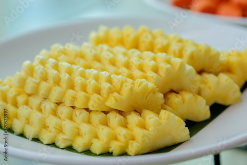 Sliced fresh ripe pineapple on white plates