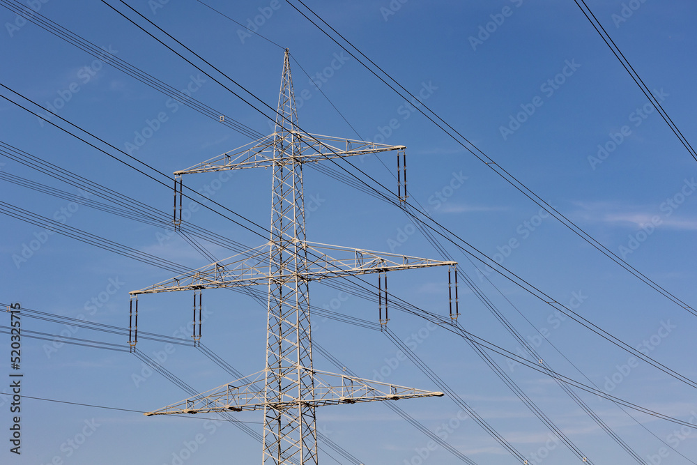 Electric pylon with cables in the landscape. Close shot of power pole against blue sky. Electric pylon with cables in the landscape. Close shot of power pole against blue sky.
