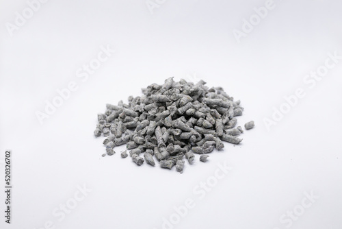 shallow depth of field photo of recycled Paper cat litter pellets on a white background