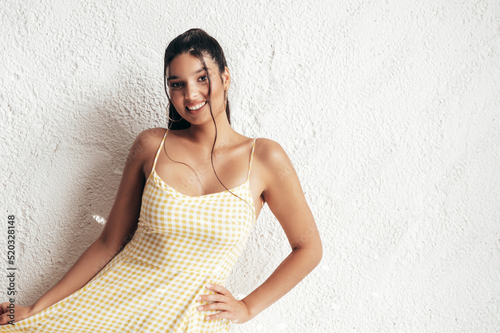 Young beautiful smiling female in trendy summer yellow dress clothes. Sexy carefree woman posing near white wall in studio. Positive model having fun and going crazy. Cheerful and happy Young beautiful smiling female in trendy summer yellow dress clothes. Sexy carefree woman posing near white wall in studio. Positive model having fun and going crazy. Cheerful and happy