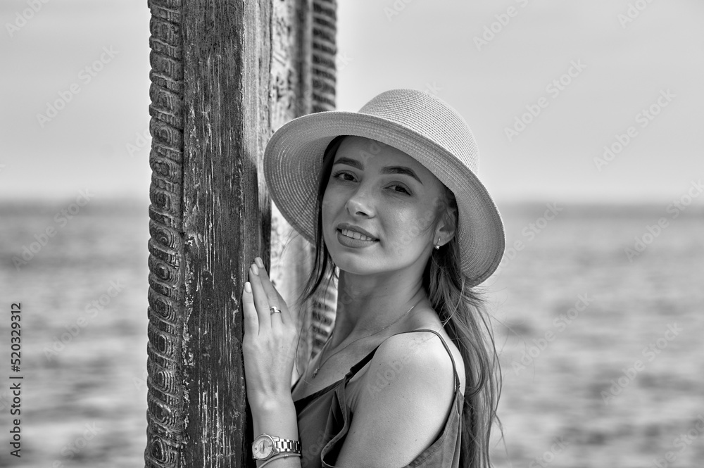 Portrait of a young beautiful girl in a hat. Black and white image