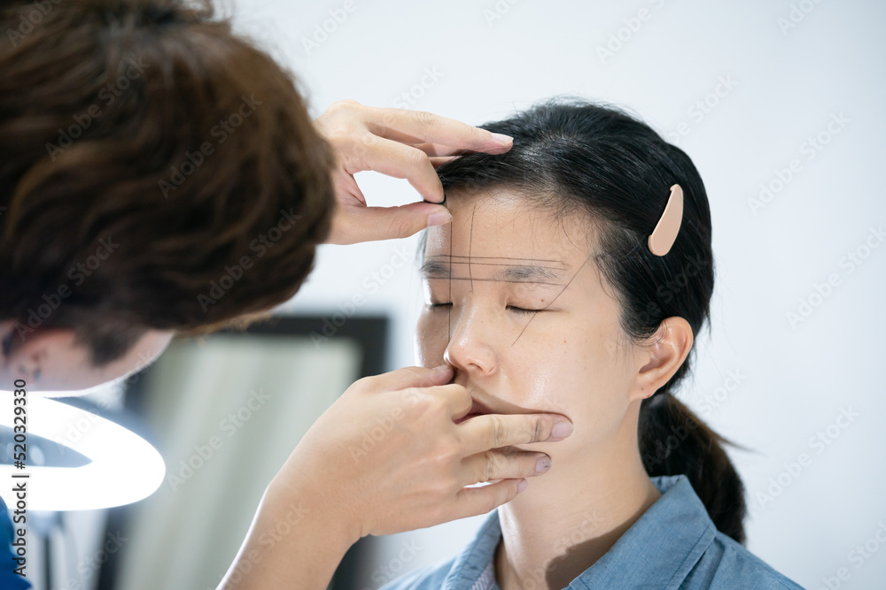 Foto de The process of shaping eyebrows by a beauty master with a