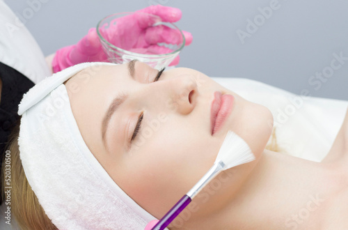 young woman is applied with a brush to the mask on the face. Procedure at the cosmetologist. Relax