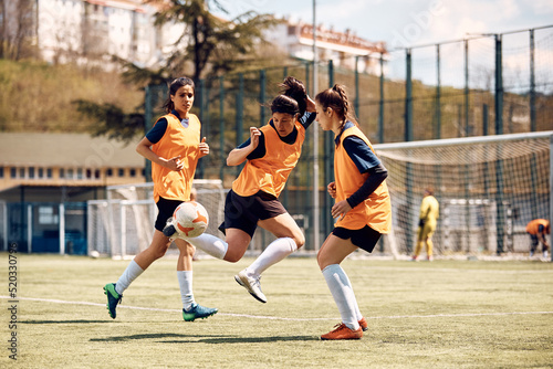 Skillful female soccer player in action during sports training at stadium. © Drazen
