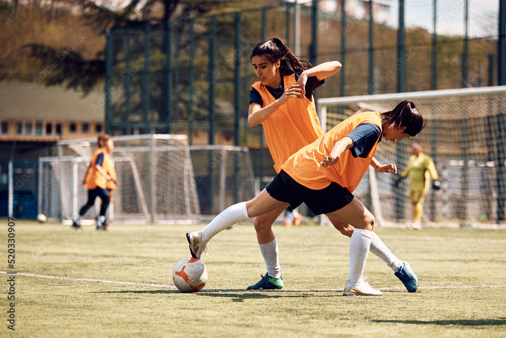 Female players in action on soccer field.
