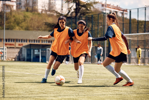 Athletic women play soccer on sports training at stadium. © Drazen
