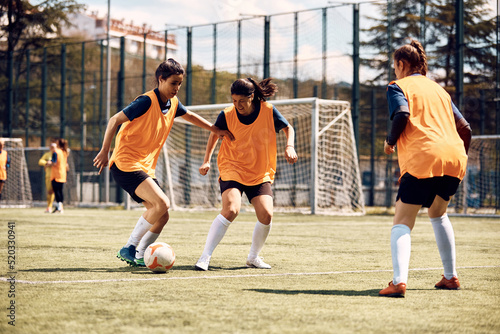 Female soccer players having sports training on playing field. © Drazen