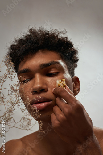 Black guy apply ice slice with plant on his face