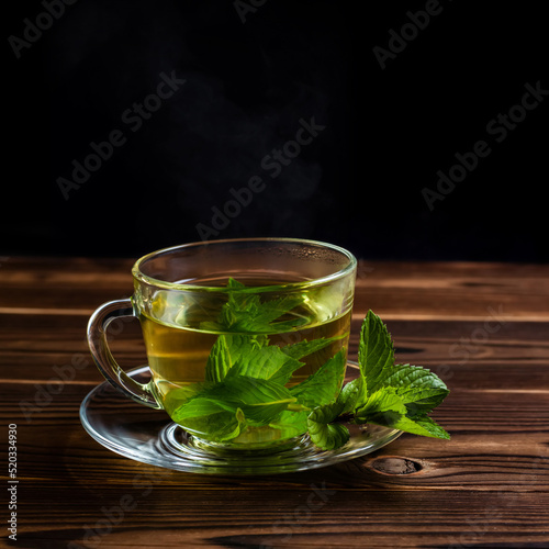 Cup of mint tea and a bunch of mint on the table