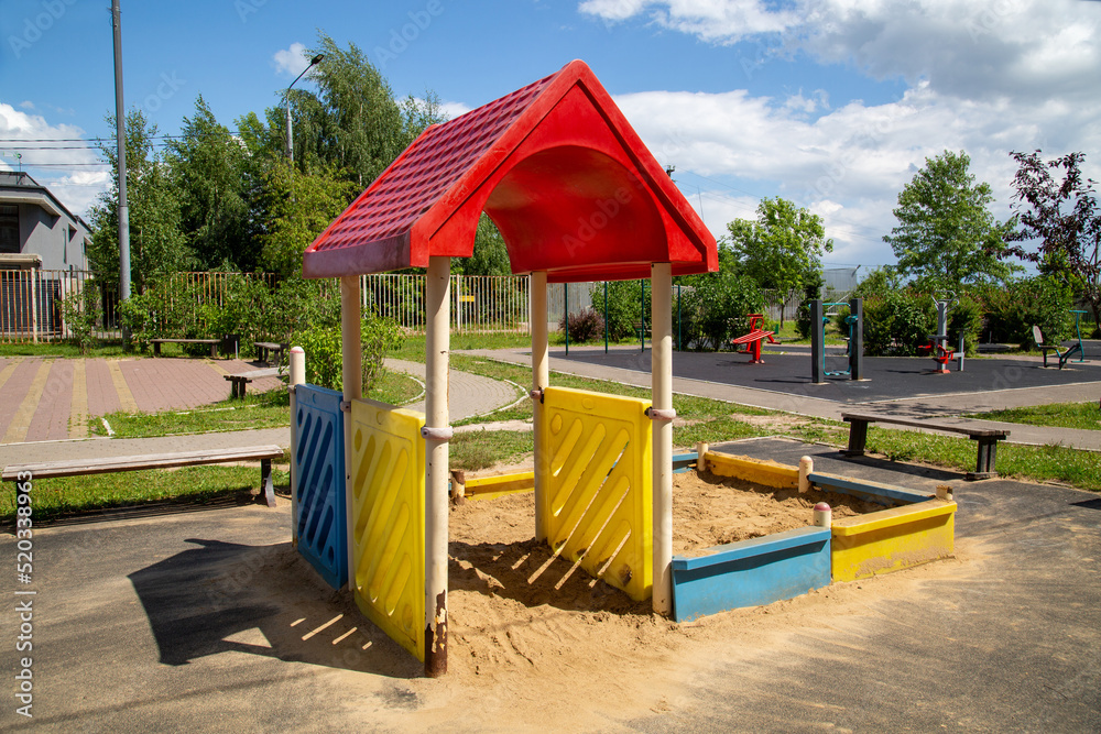 A canopy made of plastic in the form of a house with a sandbox on a playground on a bright sunny day. Playgrounds, sports, health entertainment.