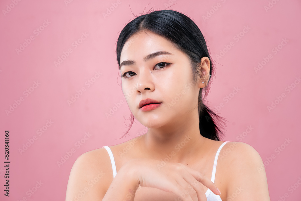 Beautiful Asian girl looking at camera isolated on pink background Beautiful Asian girl looking at camera isolated on pink background