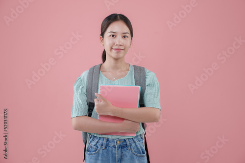Young Asian student girl backpack pink background