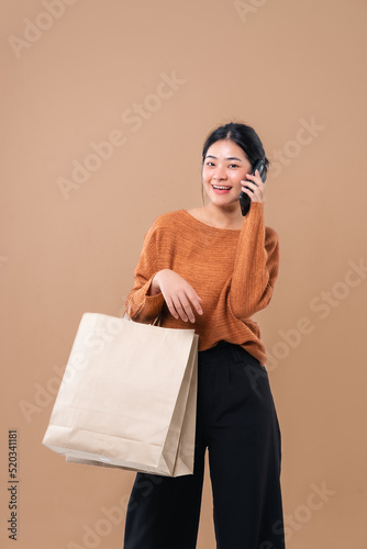 Happy Asian woman holding package parcel boxs isolated on background. Delivery courier and shippi