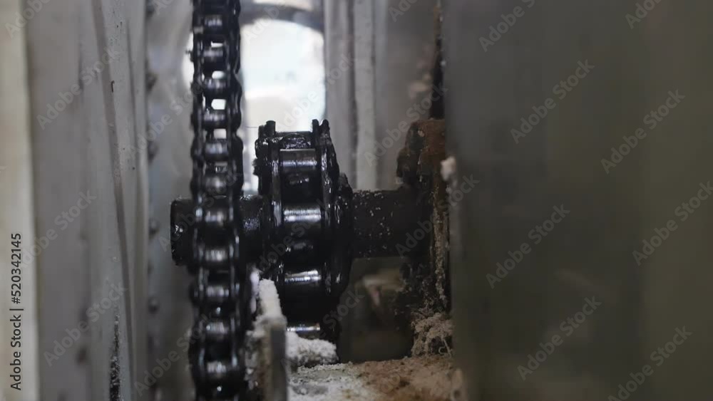 the old gear shaft rotation mechanism and the chain lubricated with black grease rotate slowly. The drive mechanism of an old machine in production clogged with dust and flour during operation the old gear shaft rotation mechanism and the chain lubricated with black grease rotate slowly. The drive mechanism of an old machine in production clogged with dust and flour during operation