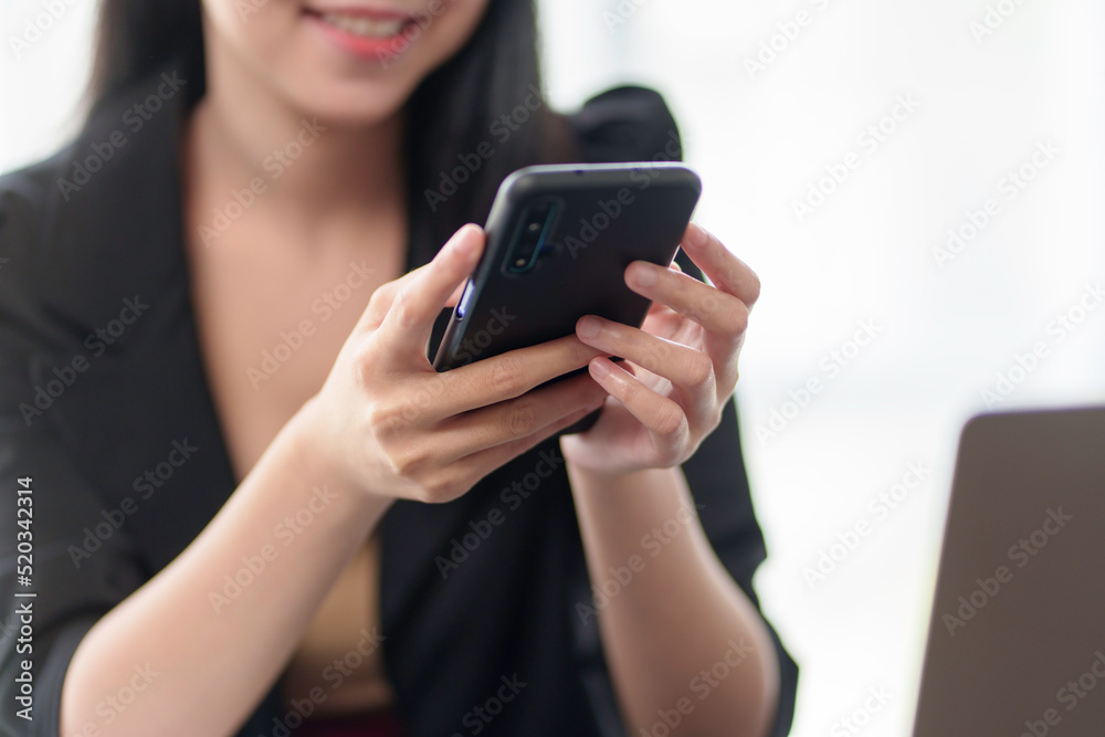 Close-up of a business woman hand using a mobile phone to play social media applications on media. Close-up of a business woman hand using a mobile phone to play social media applications on media.