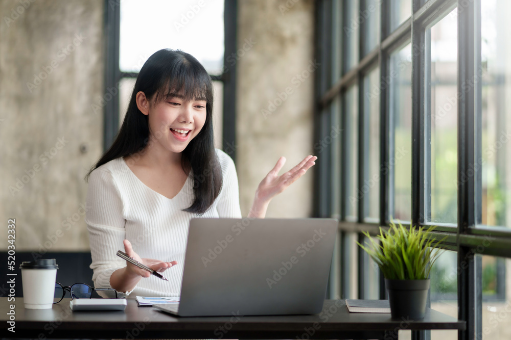 Young Asian businesswoman discussing video call on laptop computer in office Young Asian businesswoman discussing video call on laptop computer in office