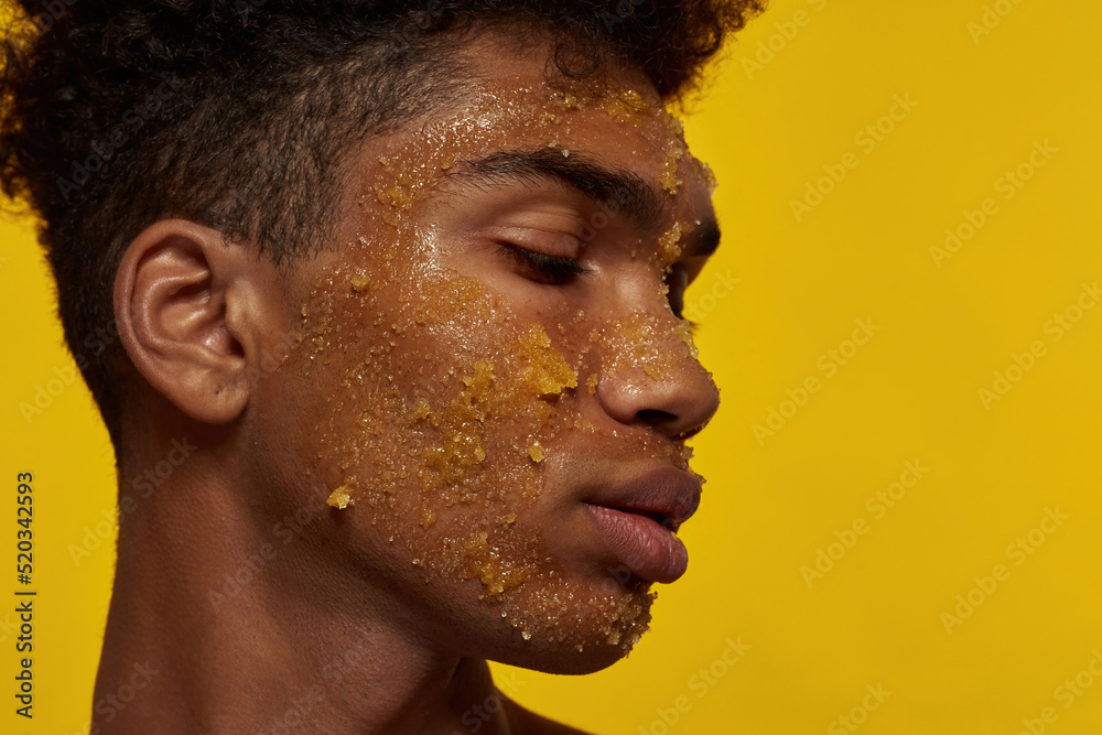 Profile of black guy with honey scrub on face skin Profile of black guy with honey scrub on face skin