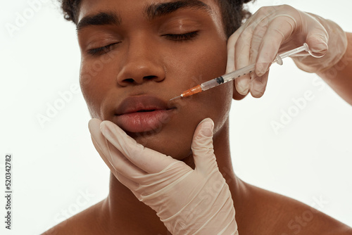 Doctor making injection of botox on guy face