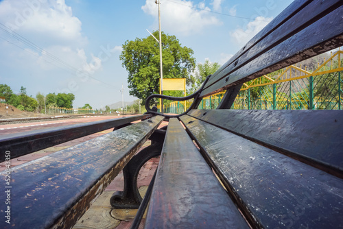 Blank railway sign board, seating bench at railway station platform of an Indian mountain village on a sunny summer day. Indian village. photo