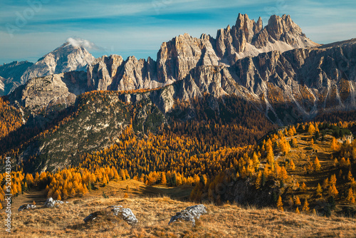 Autumn colorful larch forest and spectacular mountains in background, Dolomites