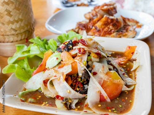 Somtum Luang prabang style, Papaya salad with background of grilled chicken rice box bamboo