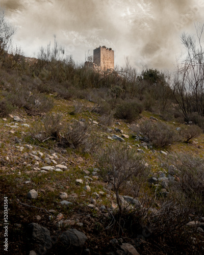 Landscape of the ruined castle of Otiñar in Jaen in the forest as a storm approaches.