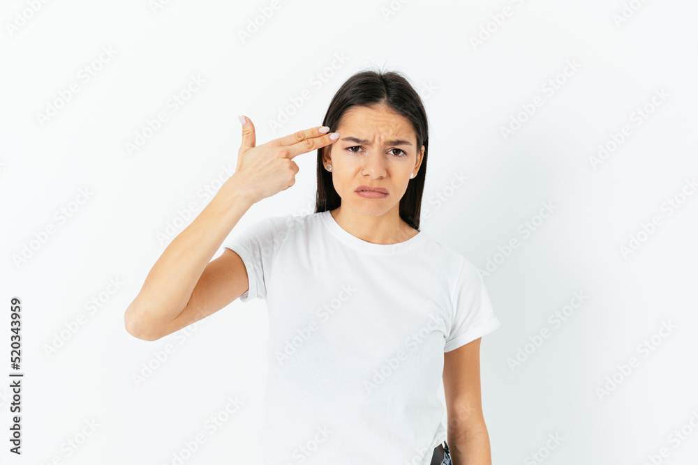Portrait of sad frustrated woman pointing finger gun to head Portrait of sad frustrated woman pointing finger gun to head