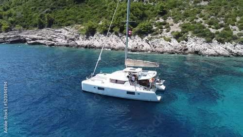 Flying around catamaran in a beautiful small bay of Croatia with final view at the sea photo