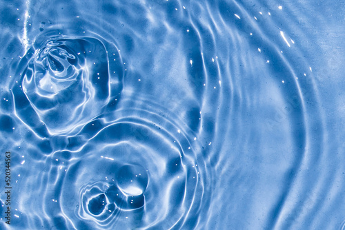 Flow of water is pouring on rippled water surface. Abstract background. Copy space for your design - stock photo