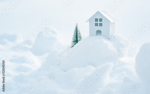 Decorative white house with a spruce tree in the snow in the sunlight outdoors, free space © shangarey