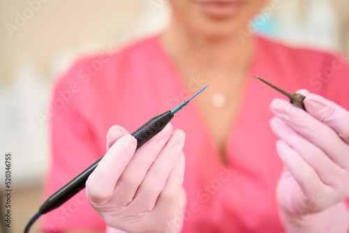 Woman beautician holds radio wave scalpel in her hands