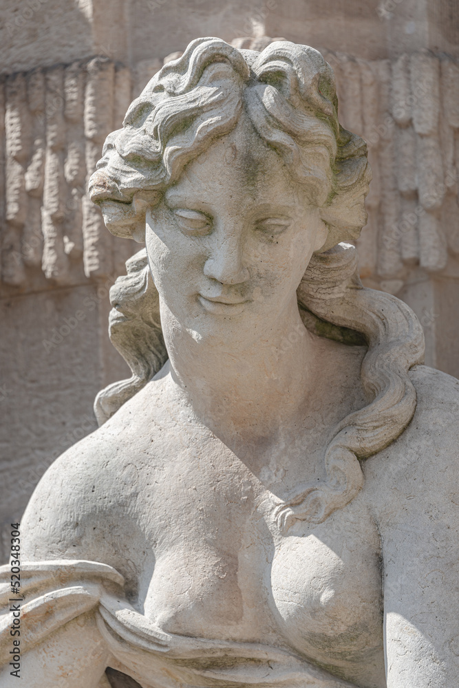 Old sculpture of a sensual woman nymph bathing at the fountain in Zwinger gardens at historical and museums downtown of Dresden, Germany.