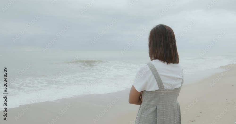 Slow motion of asian woman looking at the ocean in the morning time Slow motion of asian woman looking at the ocean in the morning time