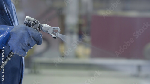 Fotografie Arm hand holding industrial size spray gun used for industrial painting and coating