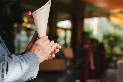 Guest with an envelope for petals at a wedding ceremony